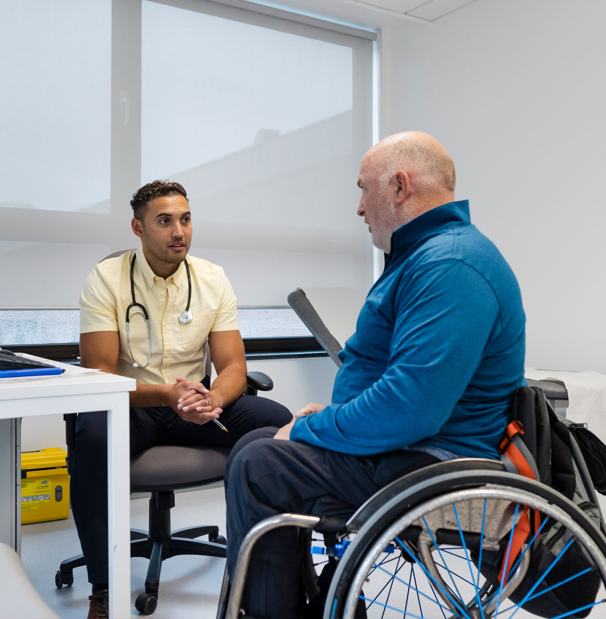 Doctor with male patient in a wheelchair