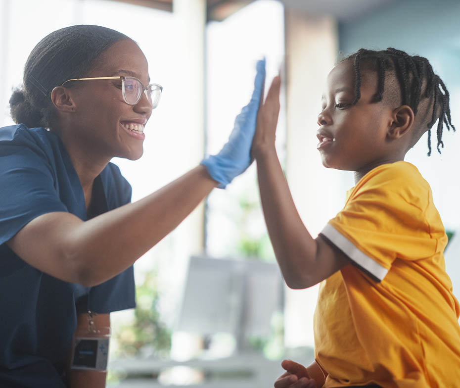 Young boy and nurse with their palms together in a high five